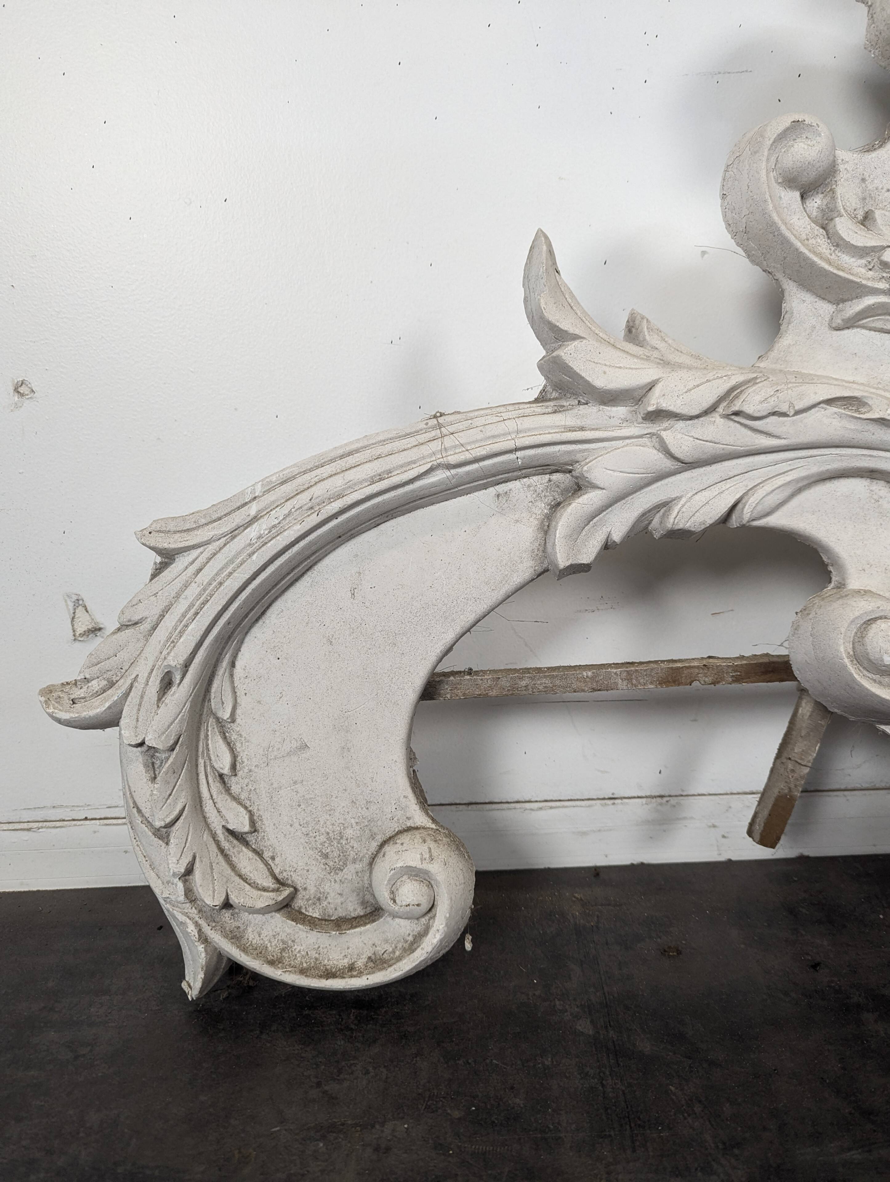 Large rococo fronton in stucco and carved wood, patinated white with an oculus.