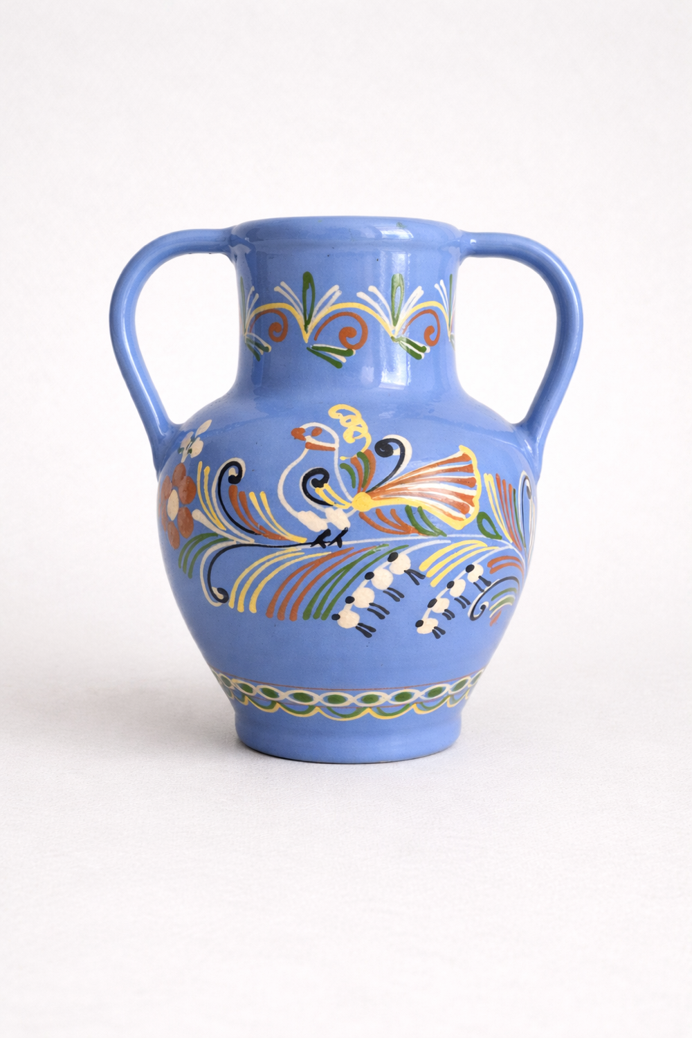 Glazed blue ceramic vase with folk decoration