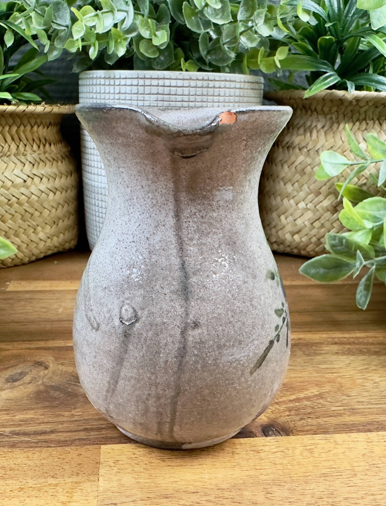 Vintage grey ceramic pitcher with hand-painted blue flower decoration.