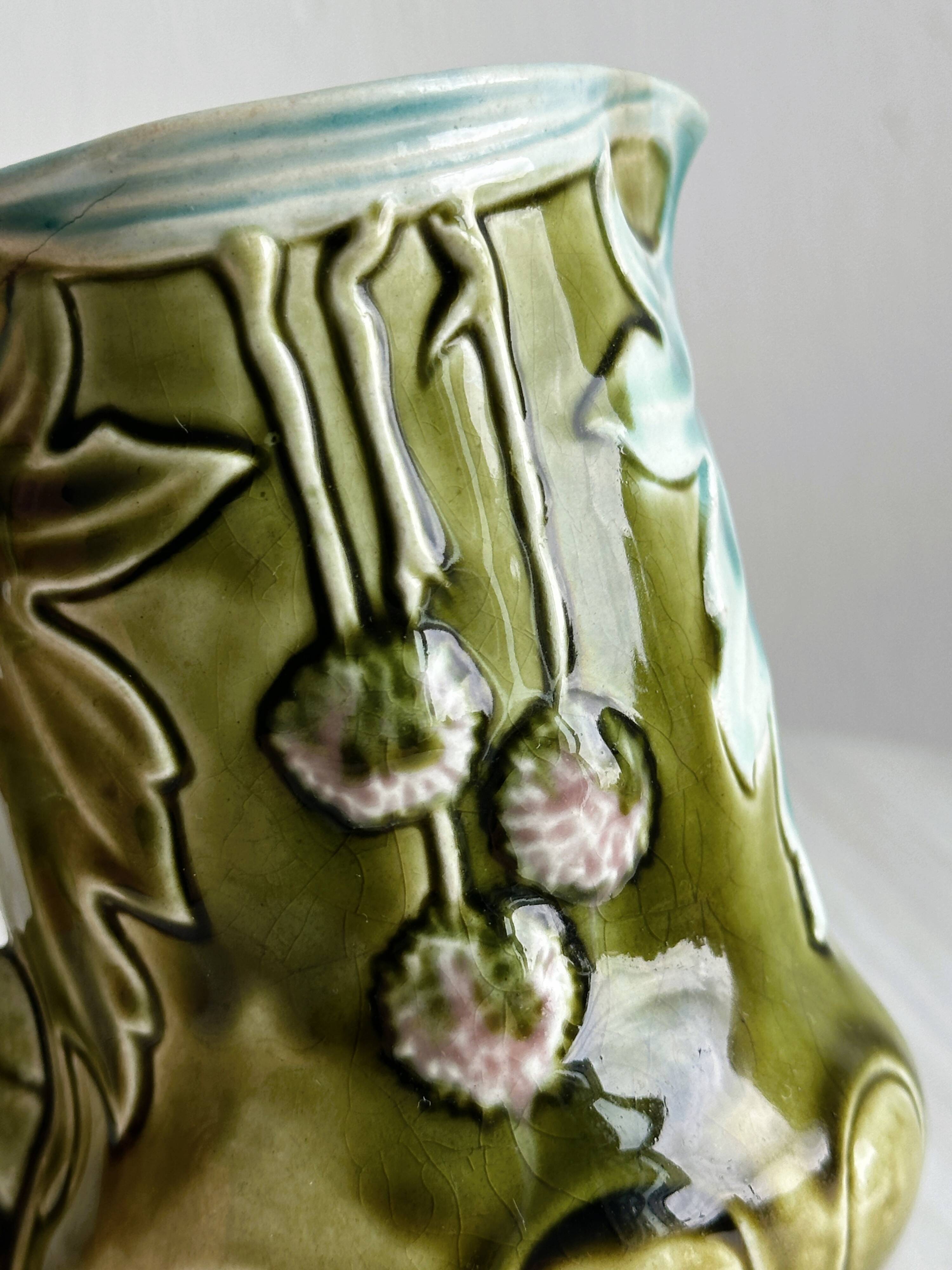 Green slip milk jug with floral patterns.