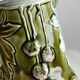 Green slip milk jug with floral patterns.