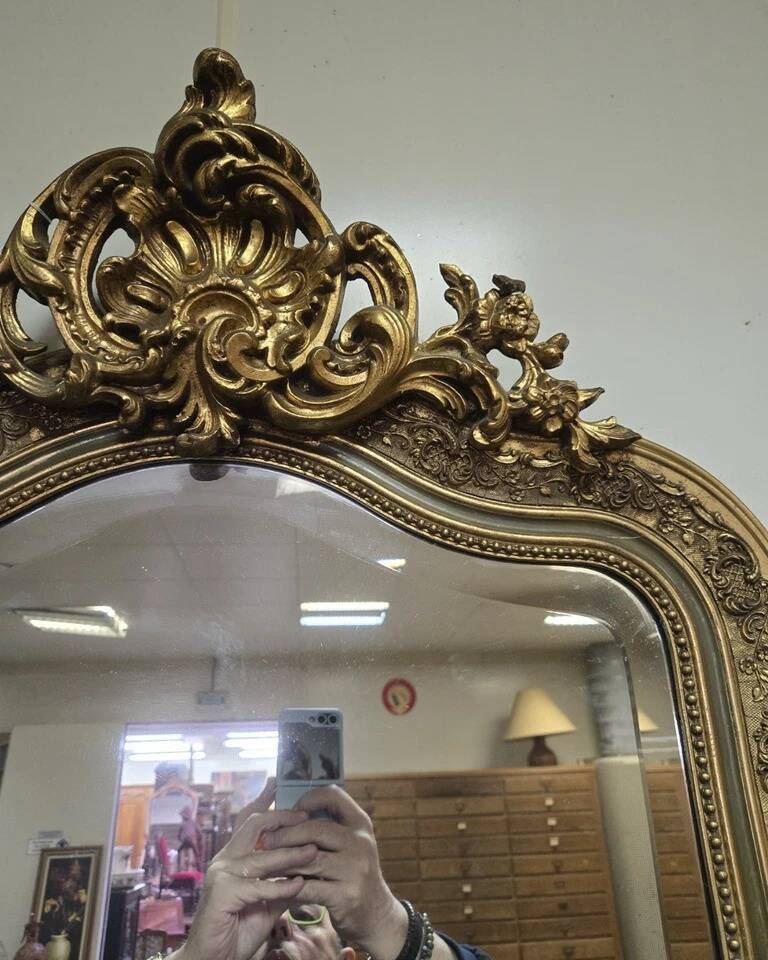 Large carved and gilded wooden mirror, rectangular in shape.
