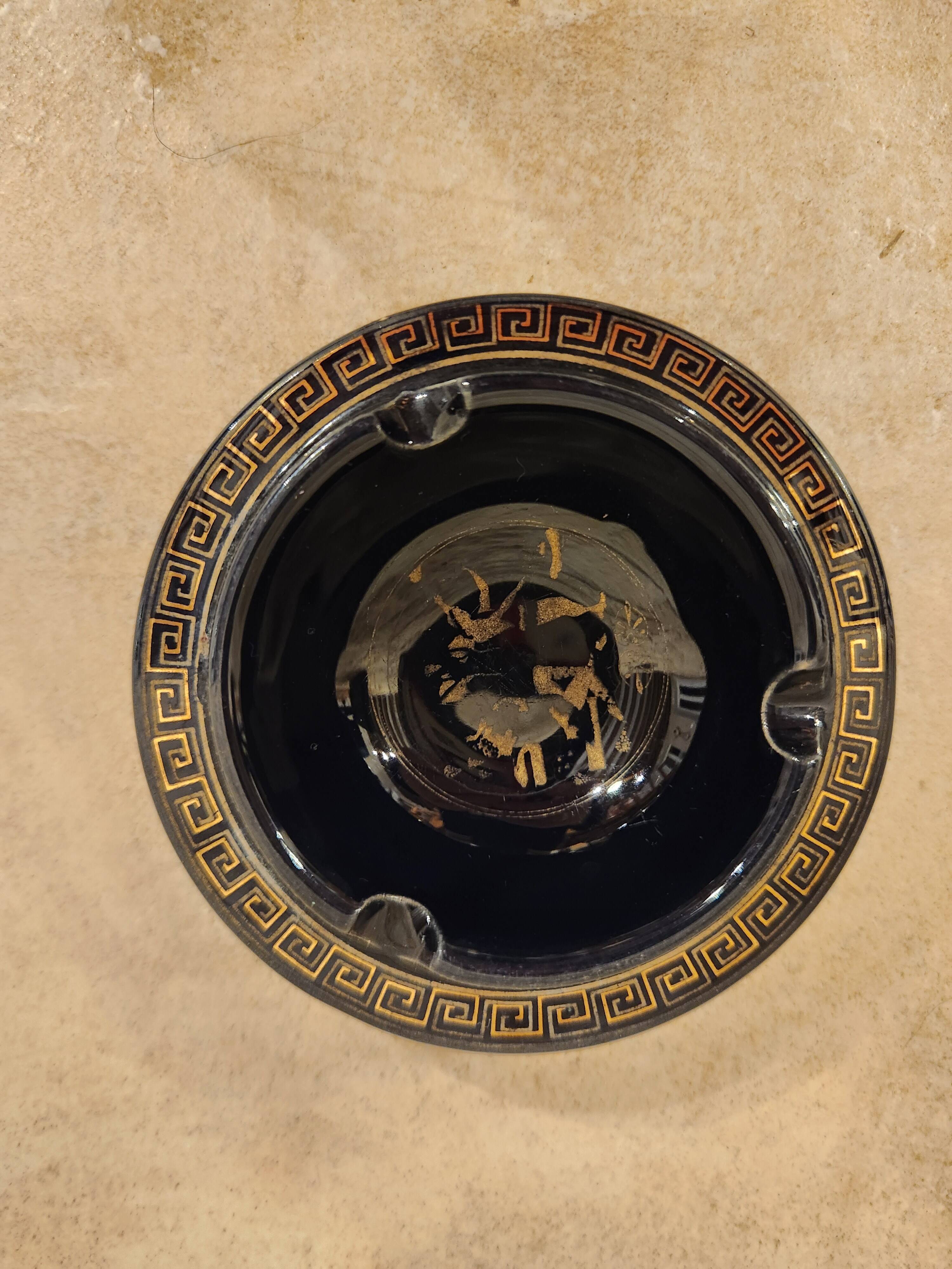 Small vintage ashtray in black ceramic with gold decoration in Greek style.