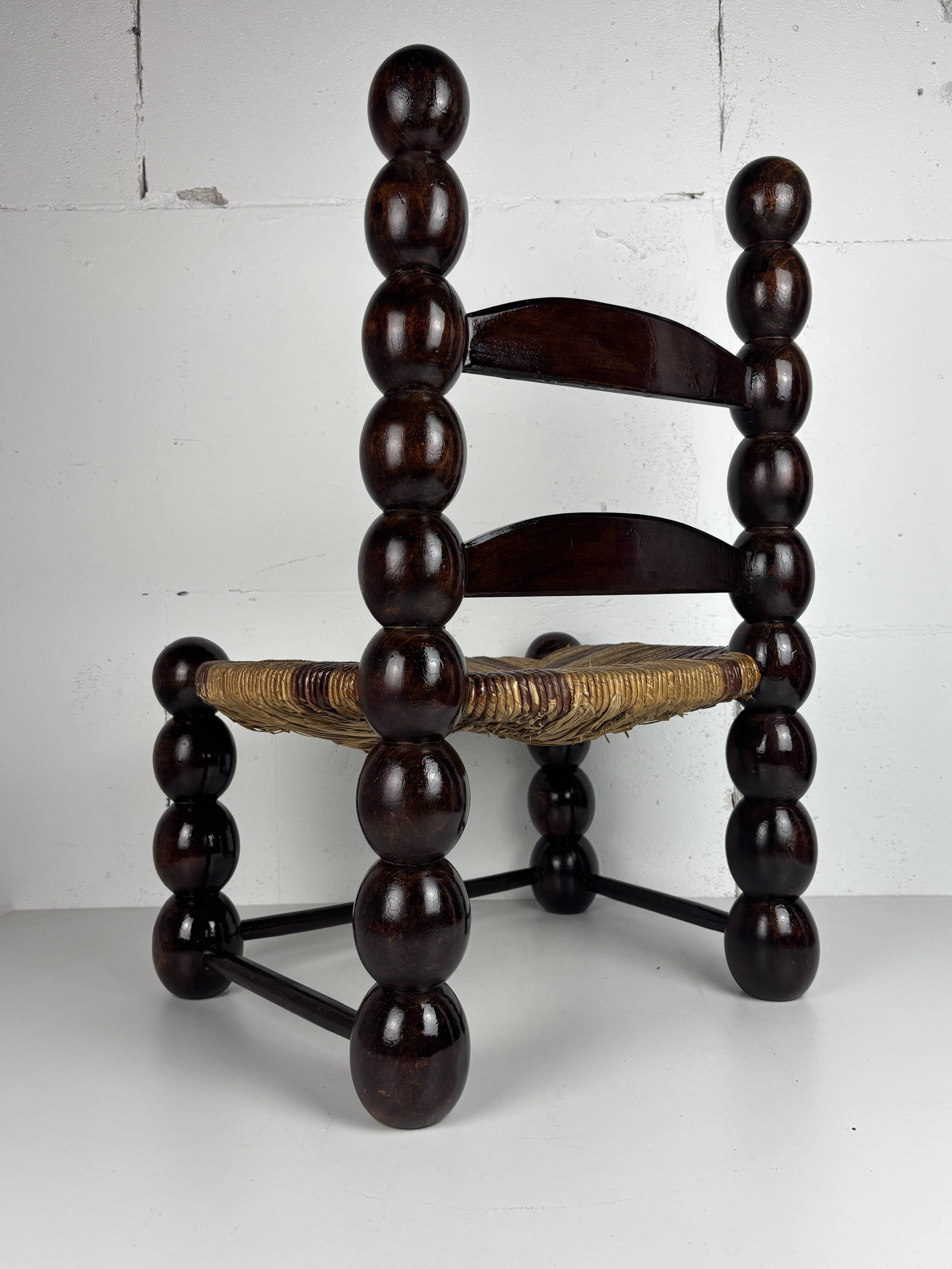 Brutalist wood turned bobbin low rush chair n the style of Charles Dudouyt