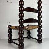 Brutalist wood turned bobbin low rush chair n the style of Charles Dudouyt