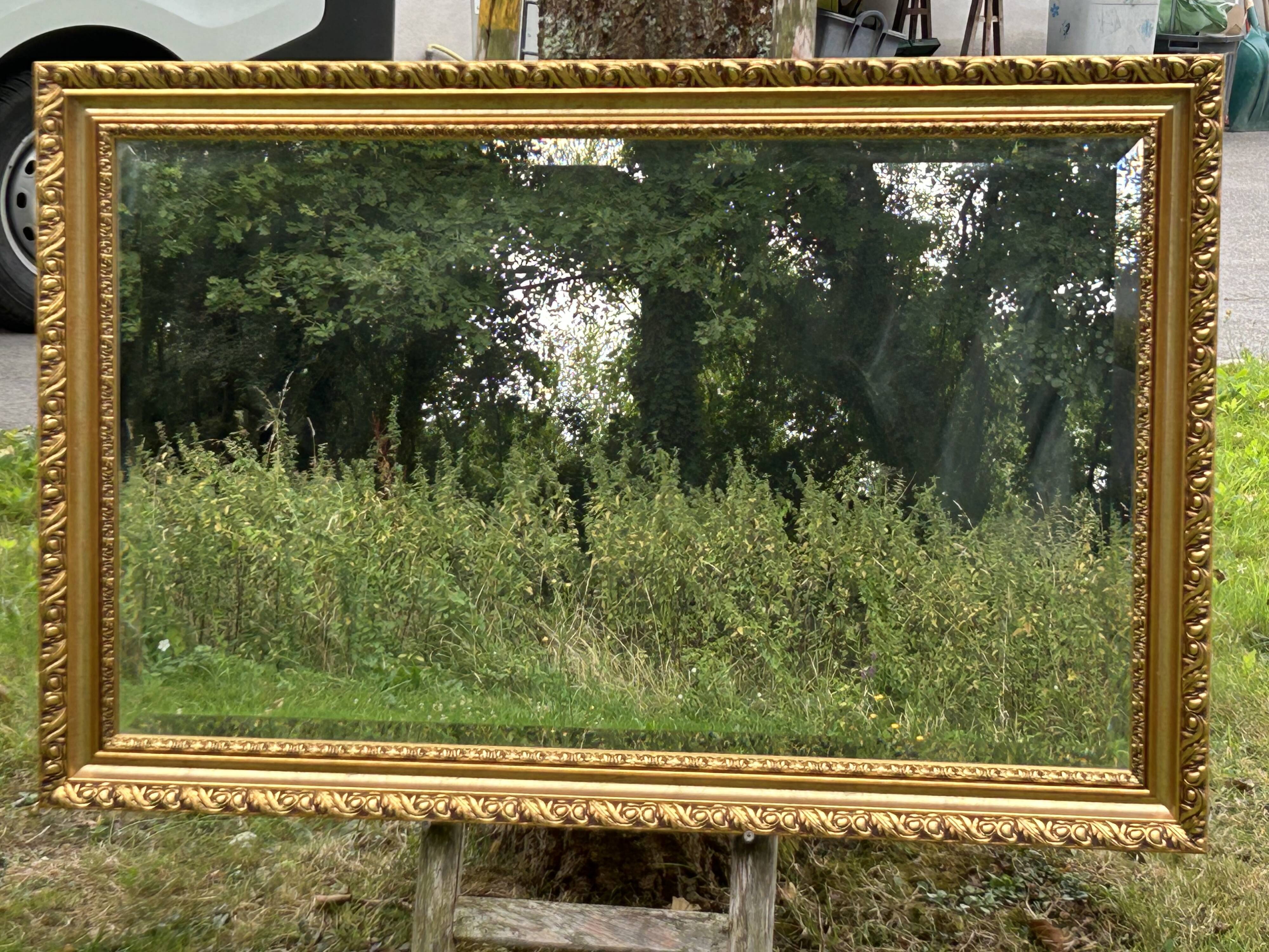 Large beveled mirror in wood and gilded stucco