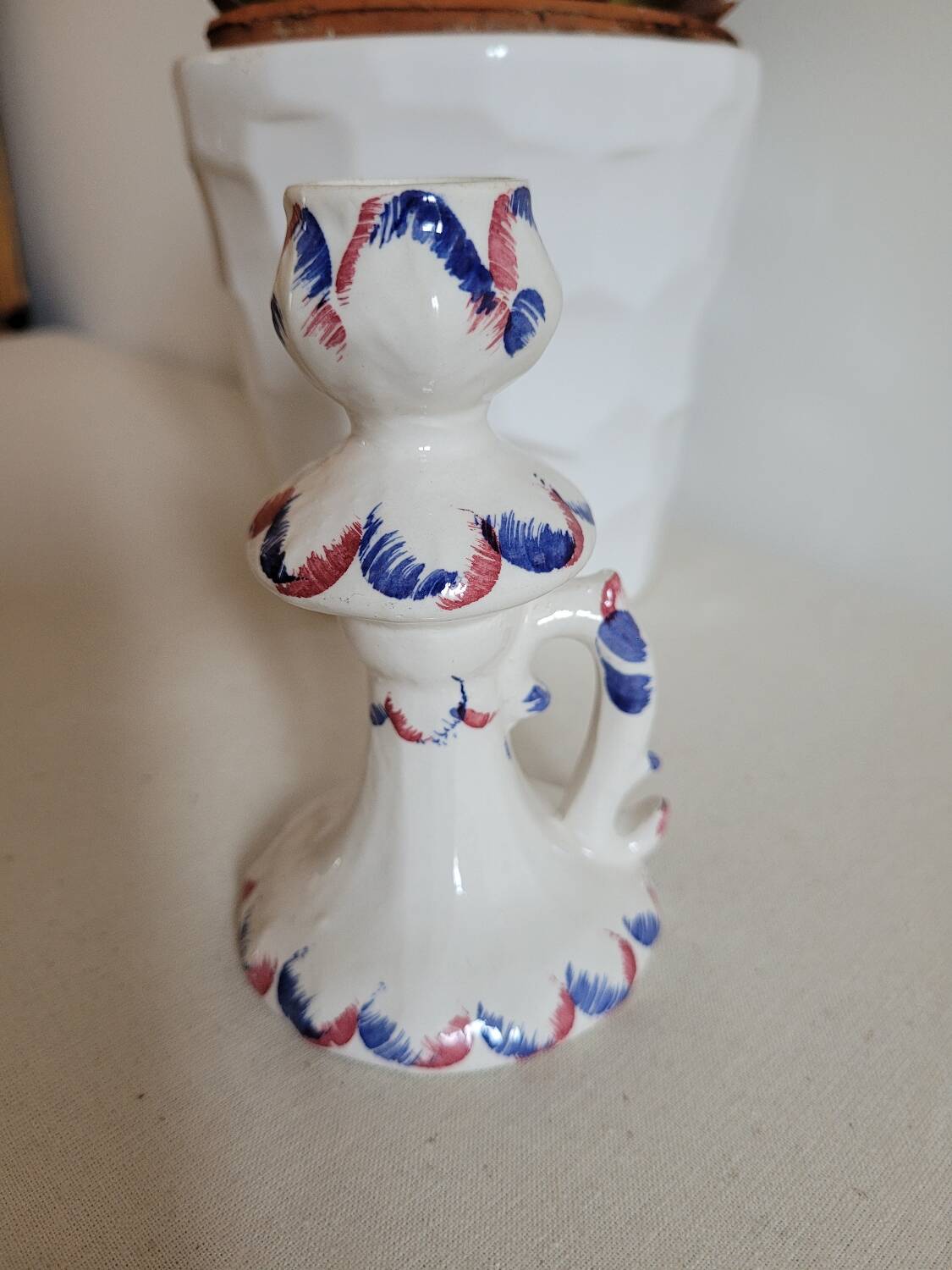 Ceramic candlestick with red and blue decoration.
