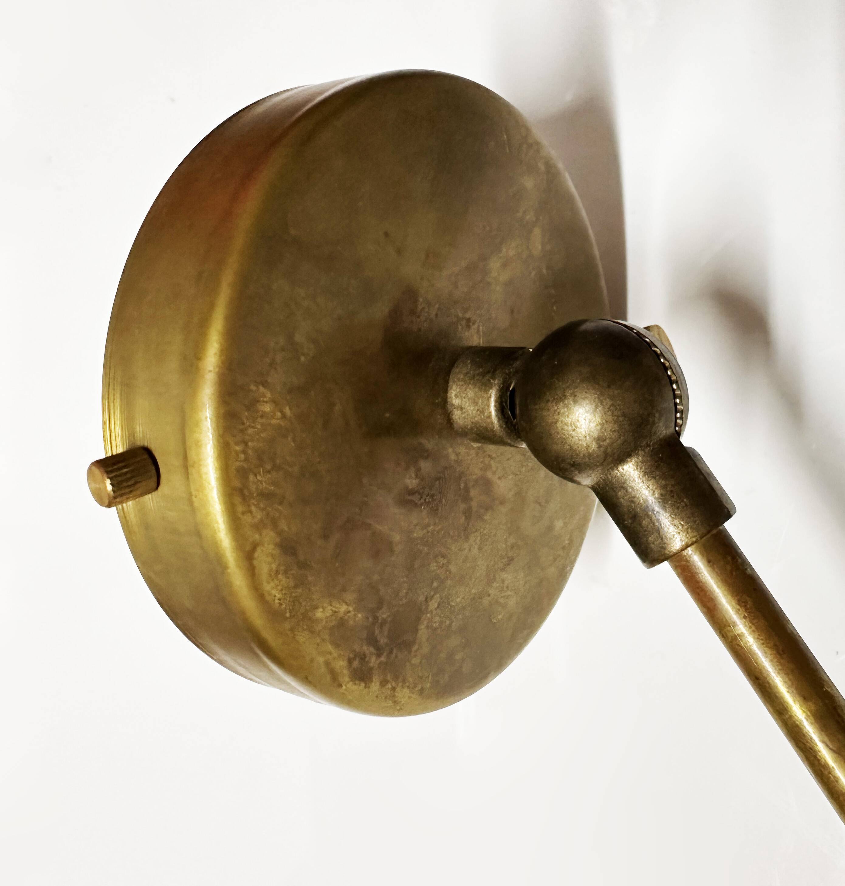 Articulated brass and lacquered iron wall light, 1950s design.