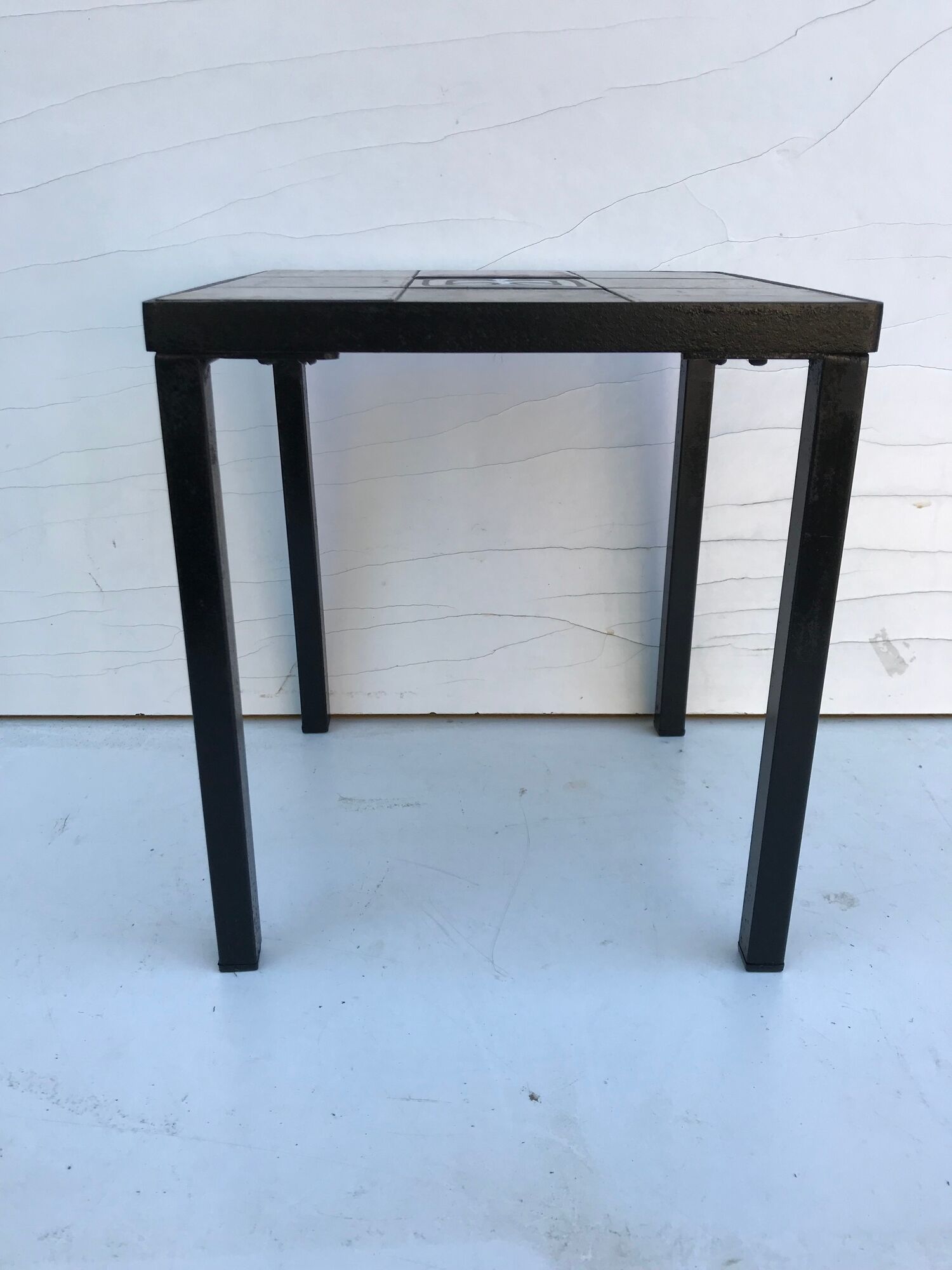 Old black metal and majolica tiles table