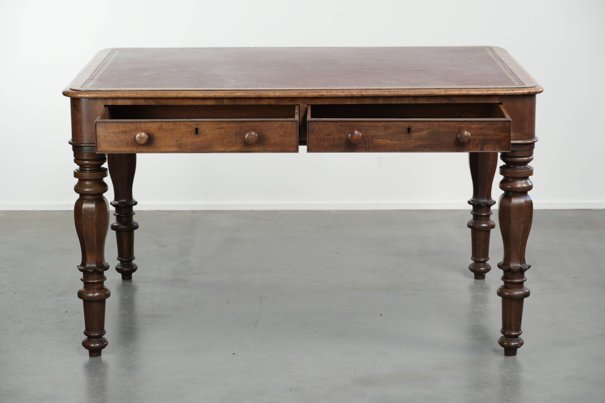 Antique English writing desk from the 19th century with a red leather top