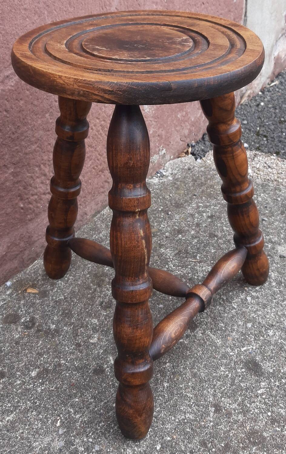 Low wooden tripod stool.