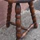 Low wooden tripod stool.