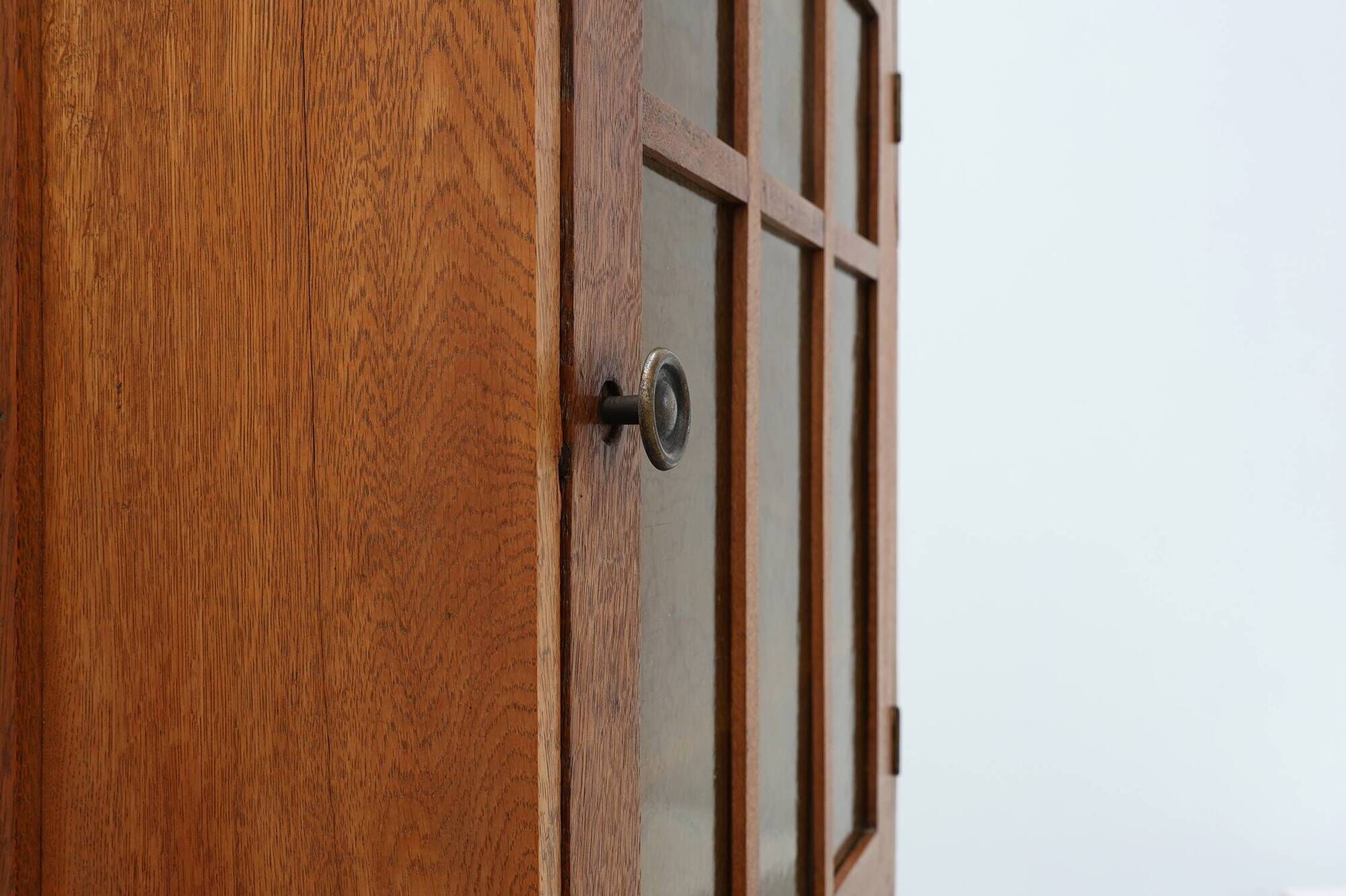 Art Deco oak wall cabinet with amber glazed door, Belgium ca. 1925