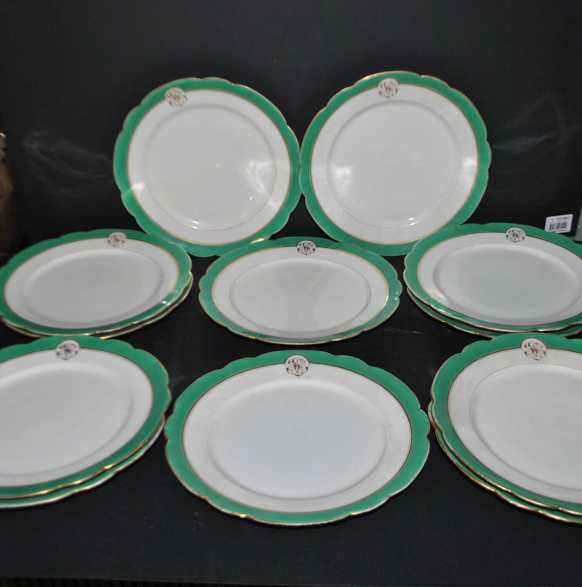 Paris porcelain set of 12 flat plates with green border and gold monogram JC.