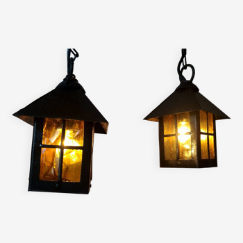 Pair of small wrought iron lanterns, orange-yellow colored windows