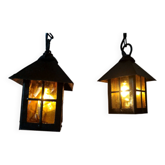 Pair of small wrought iron lanterns, orange-yellow colored windows