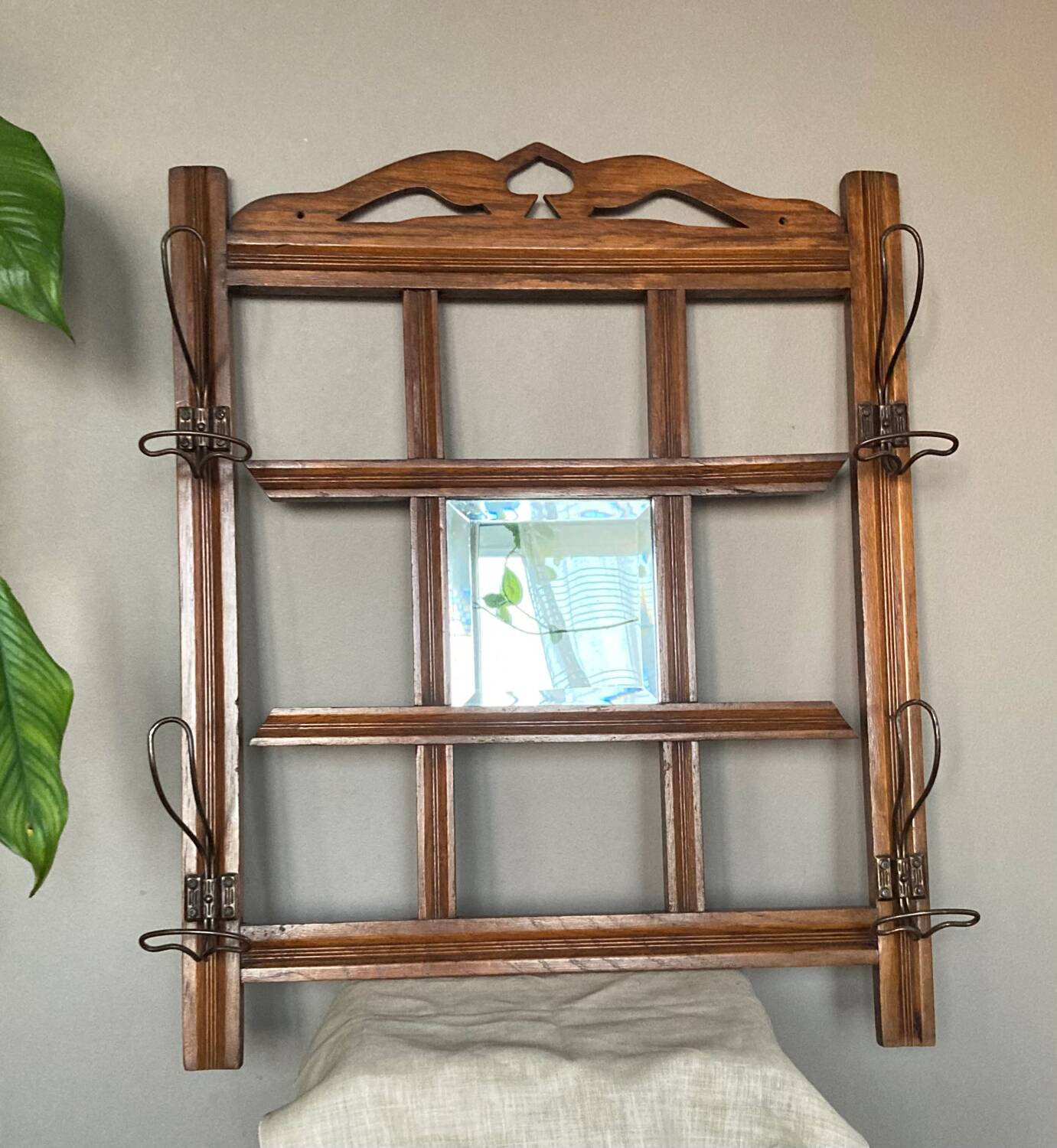 Art Deco wall-mounted coat rack in oak, early 20th century. Beveled central mirror