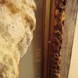 Antique gilded frame with stone lion head ornament on plexiglass