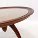 Round Art Deco side table in wood with curved legs and brass feet.