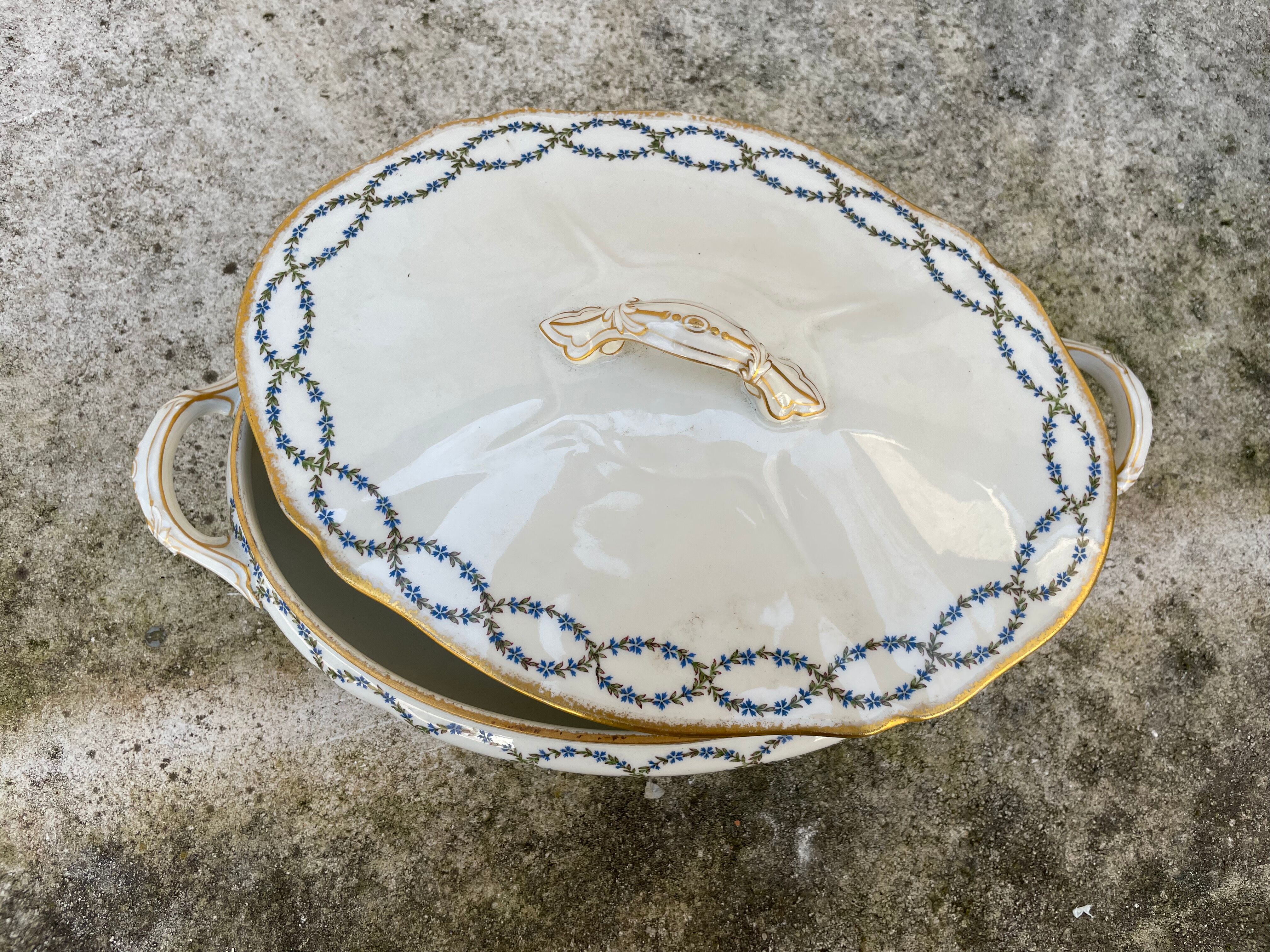 Old soup bowl with a golden border and decorated with small blue flowers