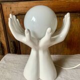 Ceramic table lamp depicting two hands holding a globe, 1980
