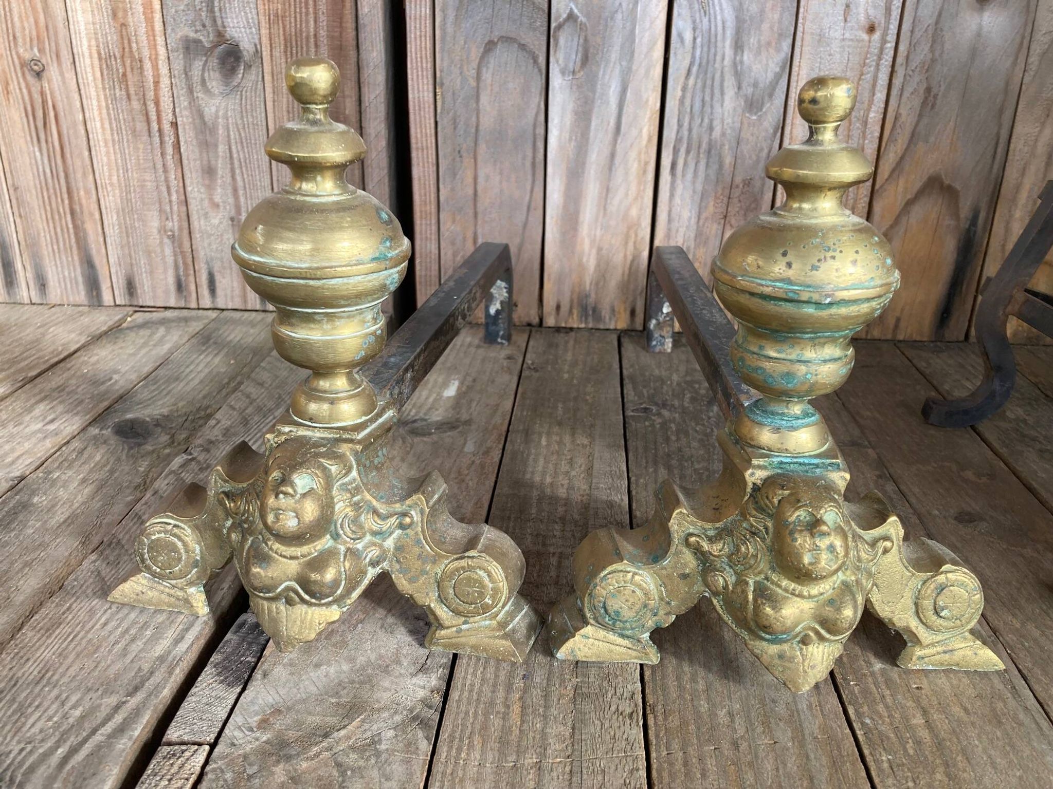 Pair of andirons and grates in cast iron and bronze with gilded grotesques, 17th century