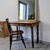 Antique writing table in the Napoleon III style with turned wooden legs.