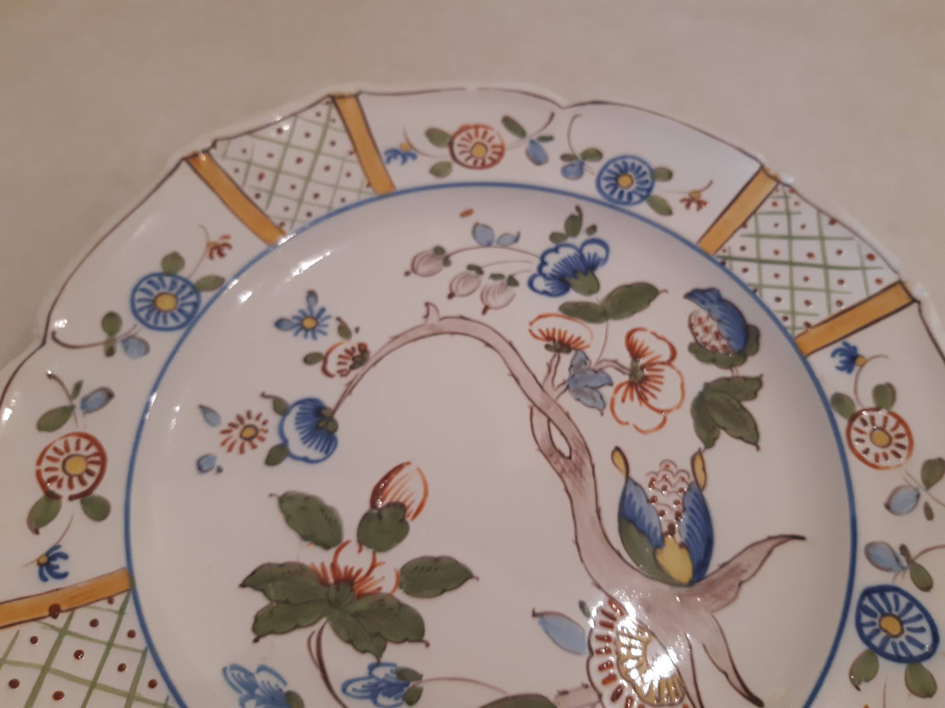 Flat plate in earthenware, hand-painted rural decoration partly in relief,