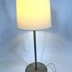 Large brushed metal table lamp with an ecru shade.