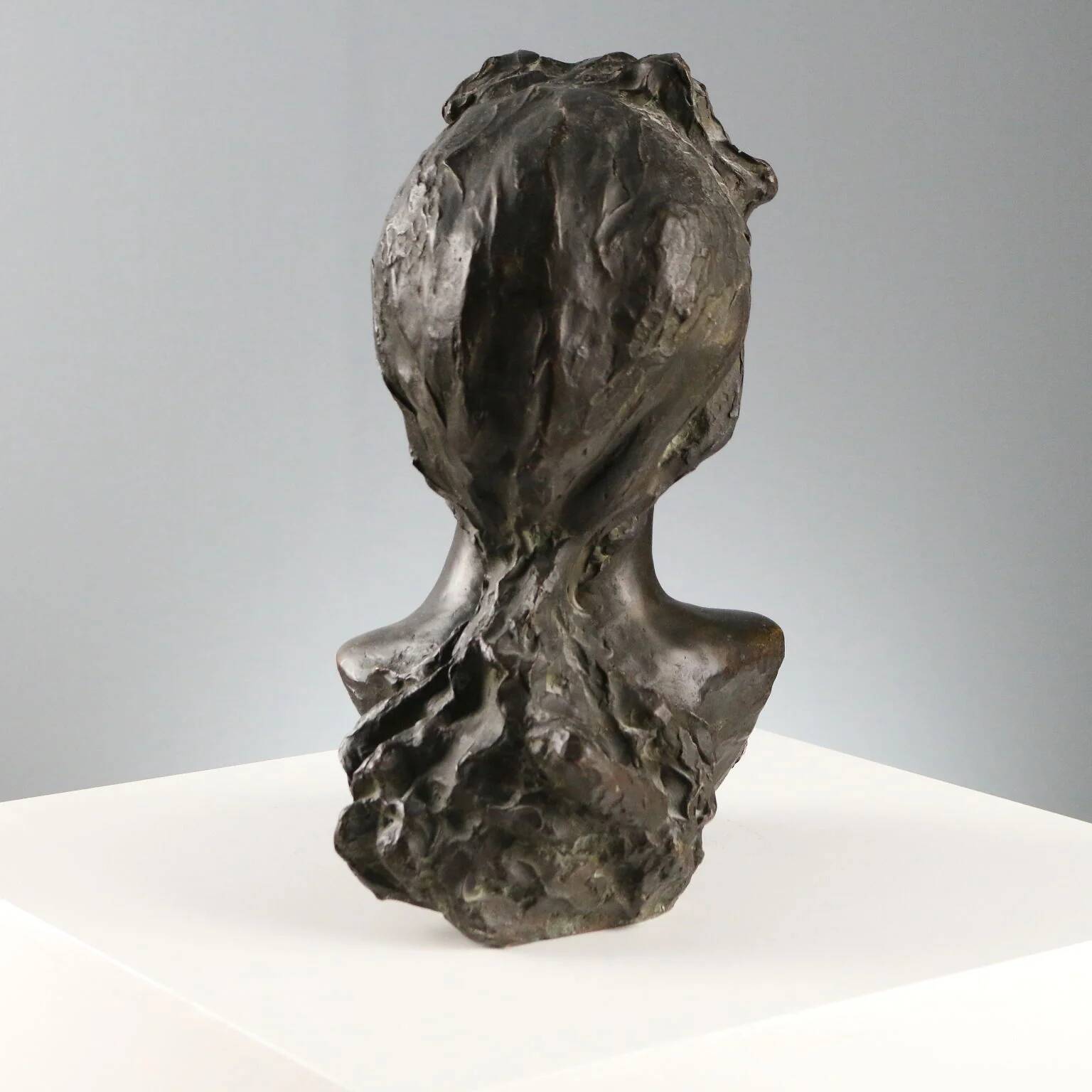Ancient sculpture of a young woman's face in bronze, 19th-20th century.