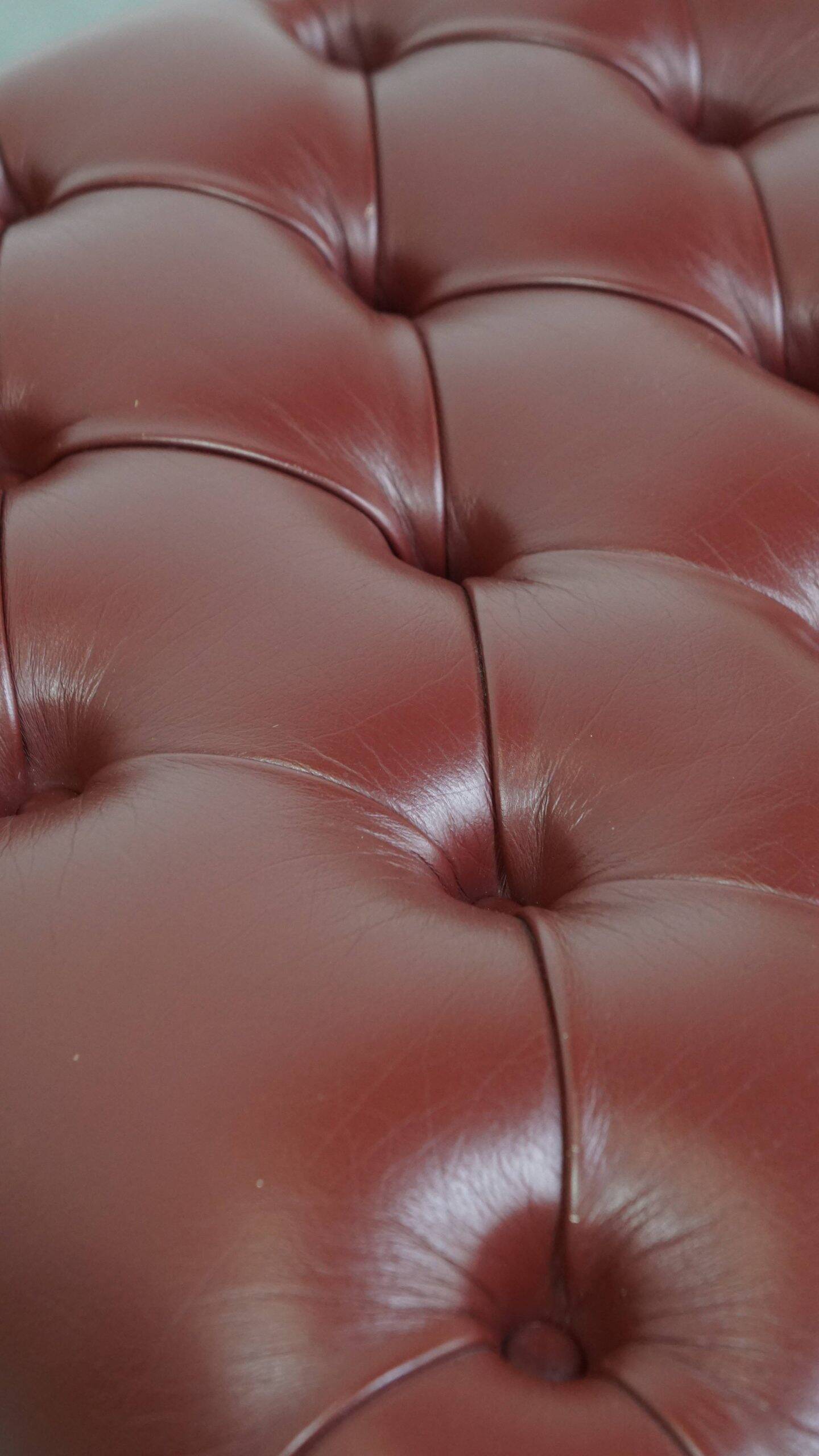 In very good condition elegant red/brown chesterfield ottoman made of cow leather