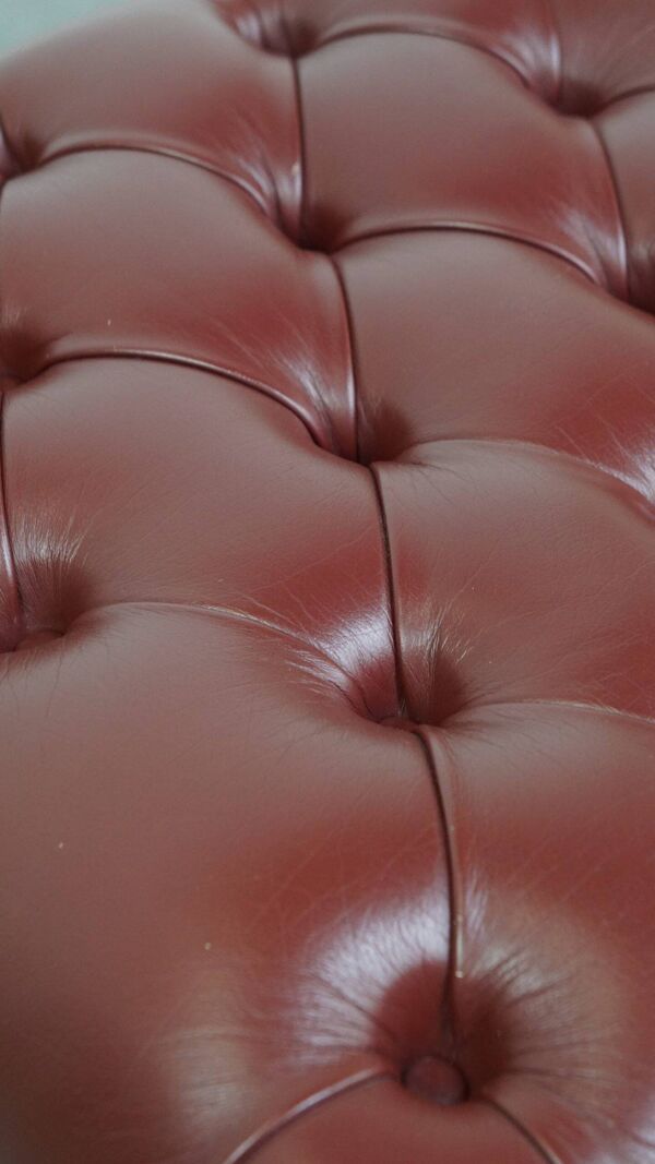 Pouf Chesterfield élégant rouge/marron en cuir de vachette, en très bon état.