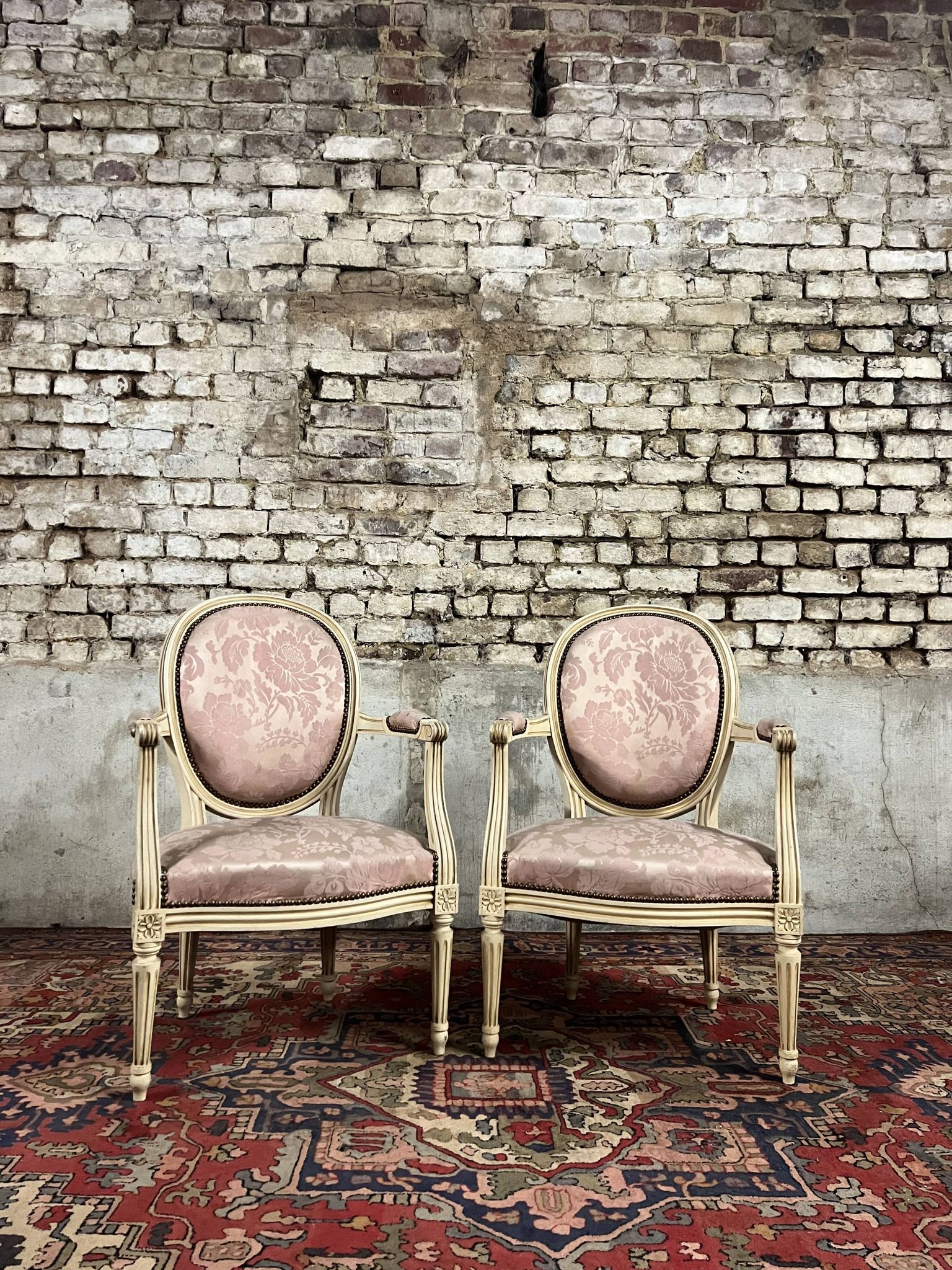 Paire de fauteuils dossier médaillon en bois laqué crème de style louis xvi