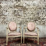 Paire de fauteuils dossier médaillon en bois laqué crème de style louis xvi