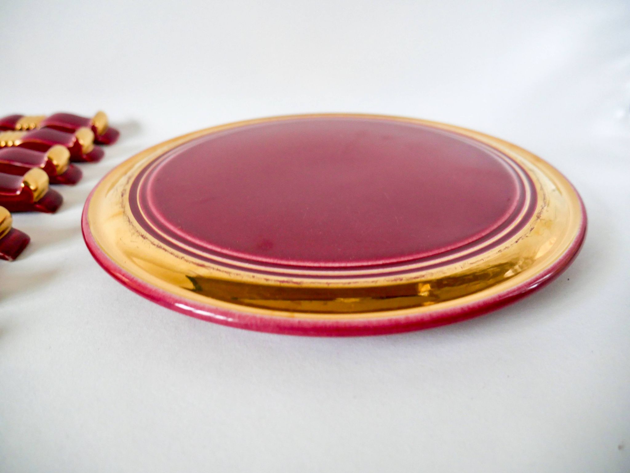 set of trivets, bottle coasters and knife holders in art de cherry-colored ceramic