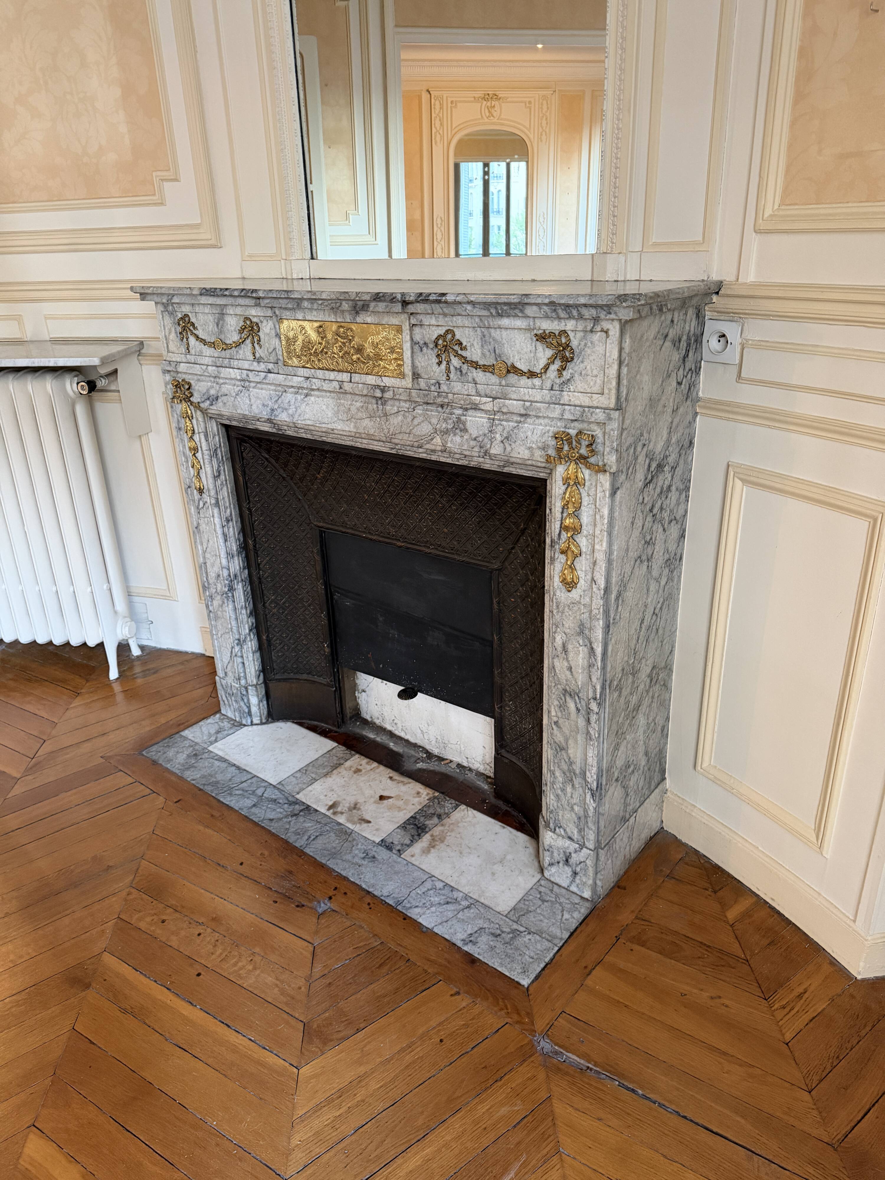Louis XVI fireplace in veined grey marble with original gilded bronzes from the 19th century.