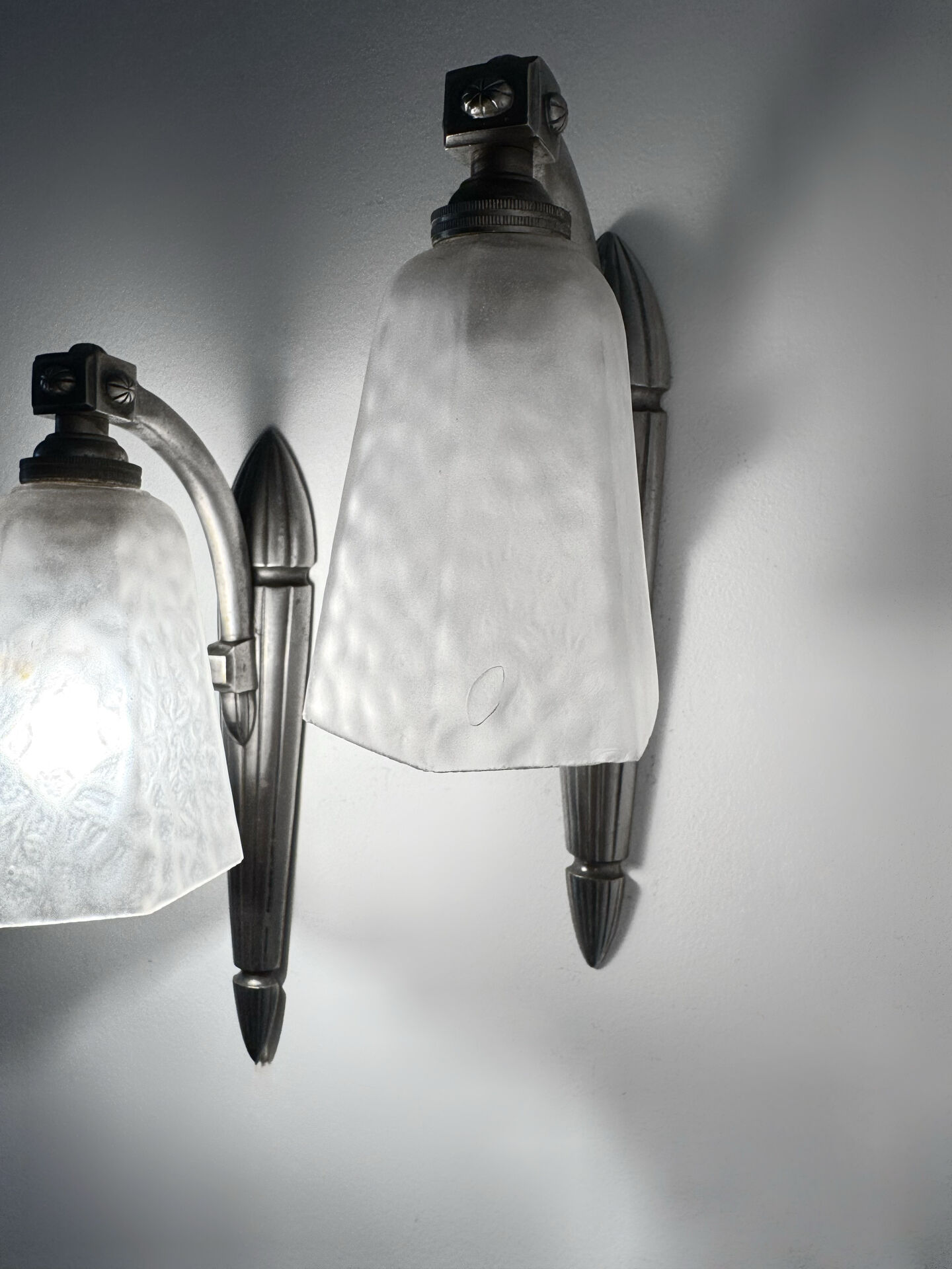 Silver Art Deco wall lights with frosted glass.