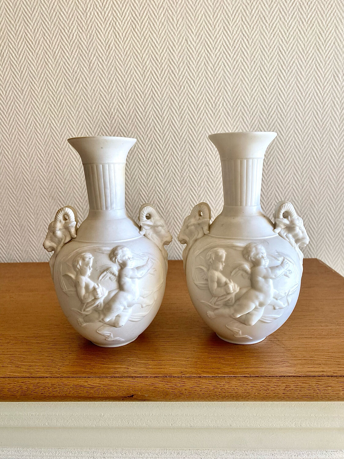 Paire de vases en biscuit decor putti et tête de bélier