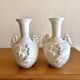 Pair of biscuit vases decorated with putti and ram's head.