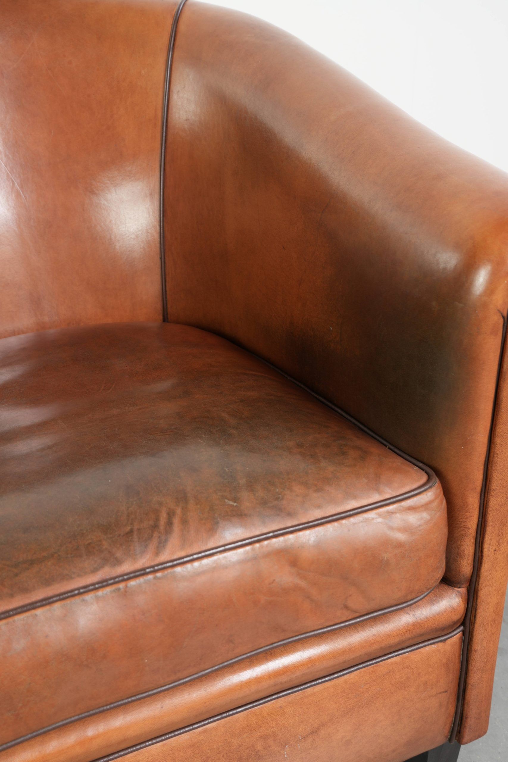 Vintage sheepskin club armchair with a warm colour scheme with black piping