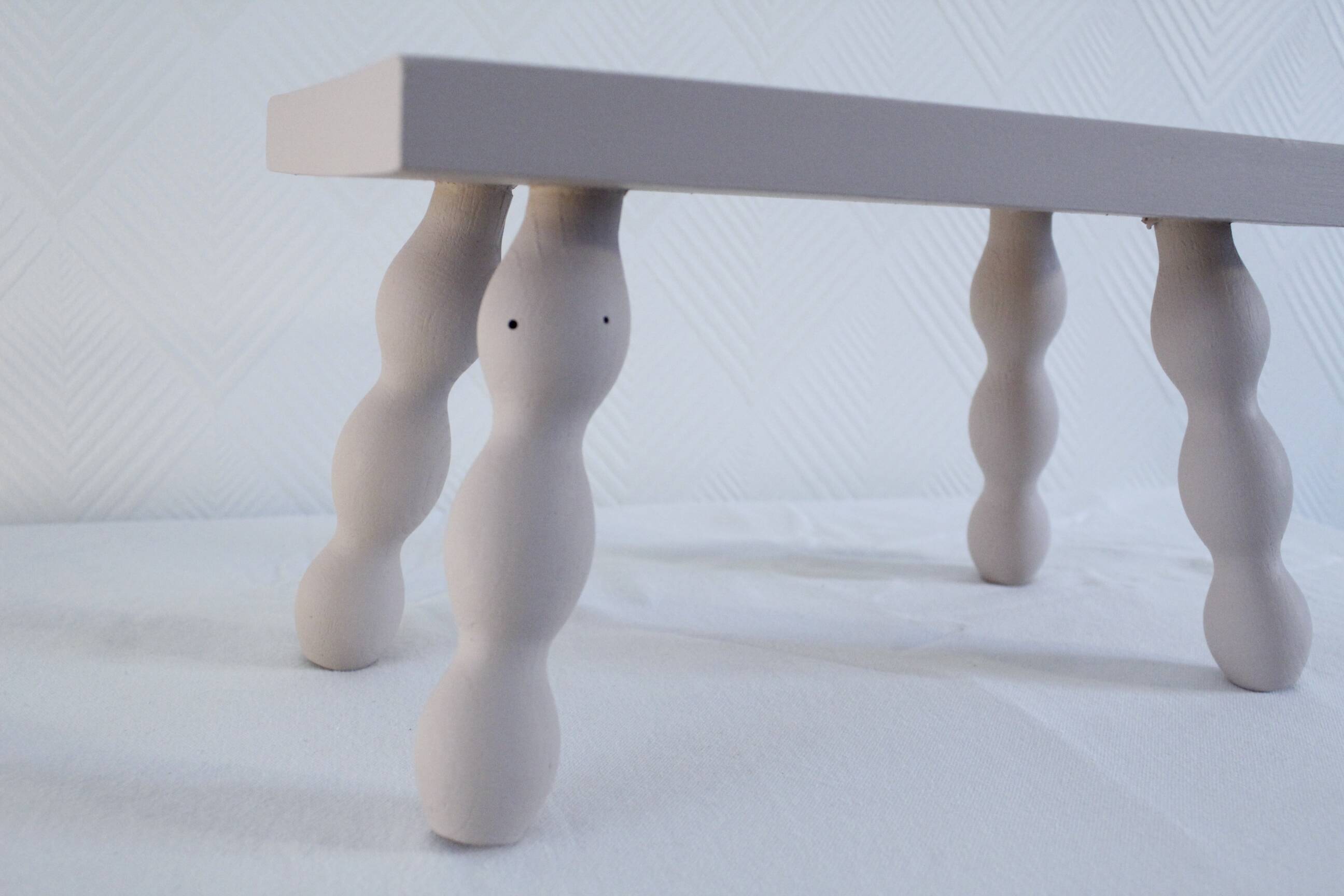 Small vintage wooden bench renovated in pinkish beige