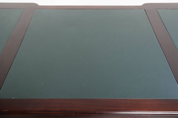 Bureau de partenaire dans le style anglais avec un bois foncé et un dessus en cuir vert.