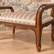 Two-seater bench in carved wood, with curved armrests.