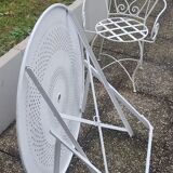 Folding round table and four wrought iron armchairs