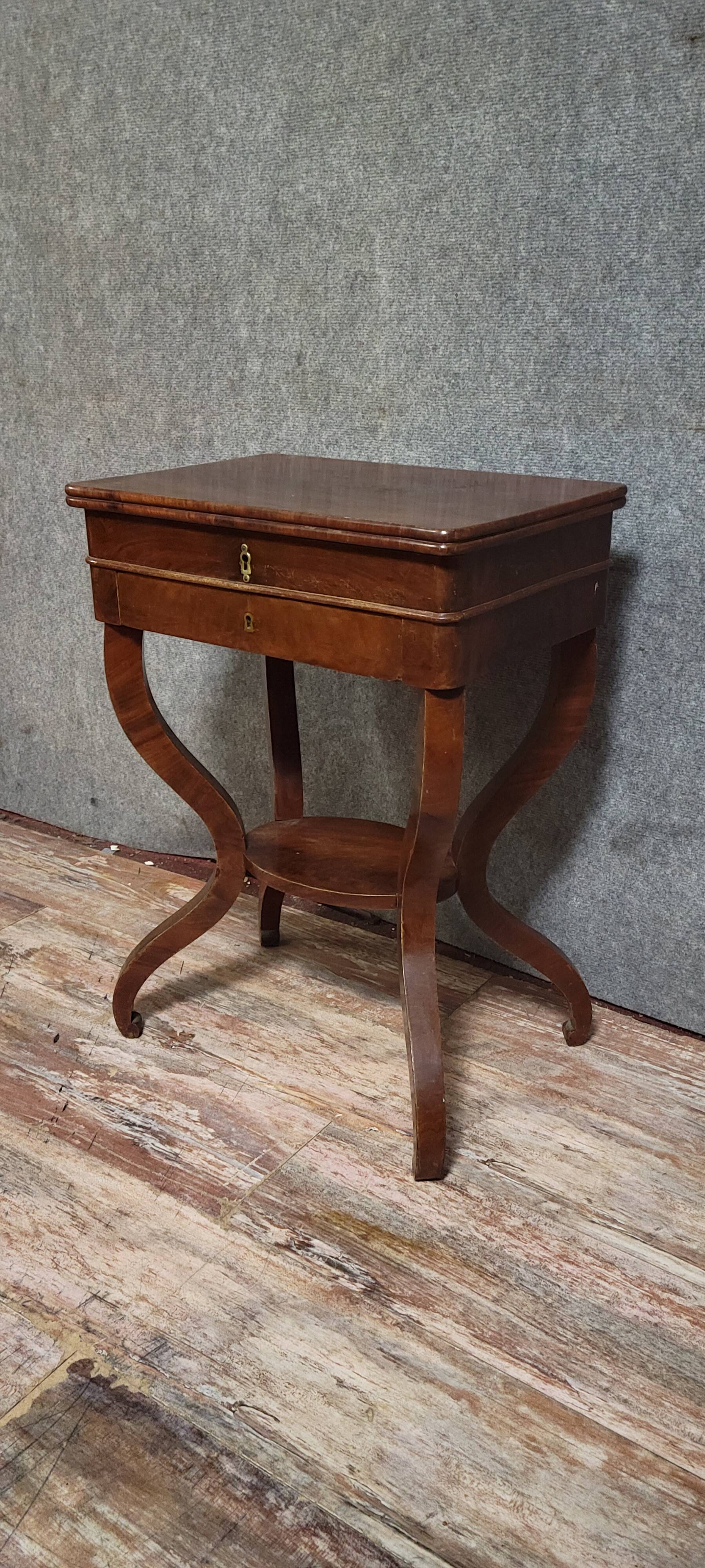 Empire writing table, in mahogany, resting on curved legs.