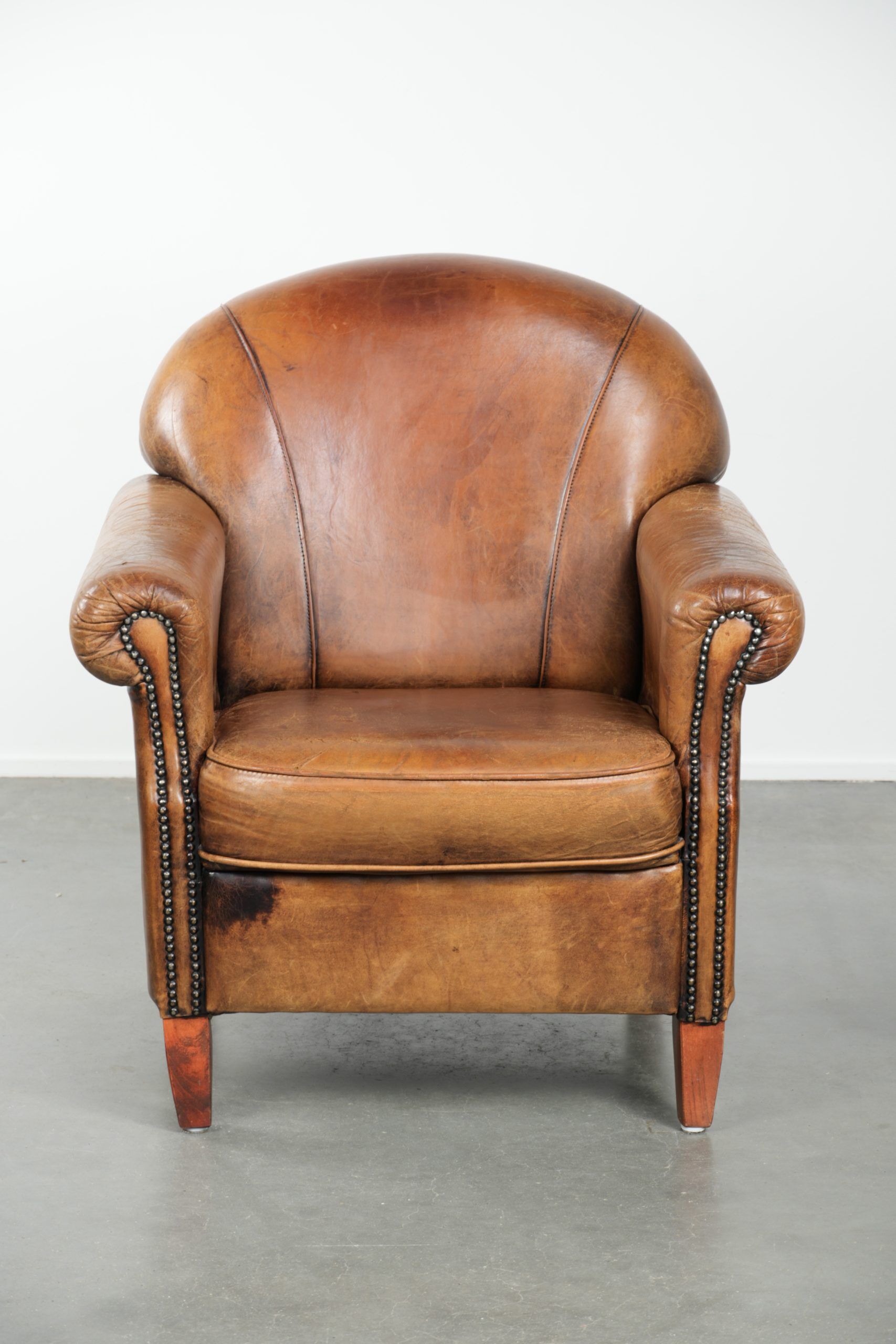Sheepskin armchair with a beautiful vintage look and decorative nail finish