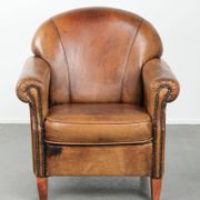 Sheepskin armchair with a beautiful vintage look and decorative nail finish