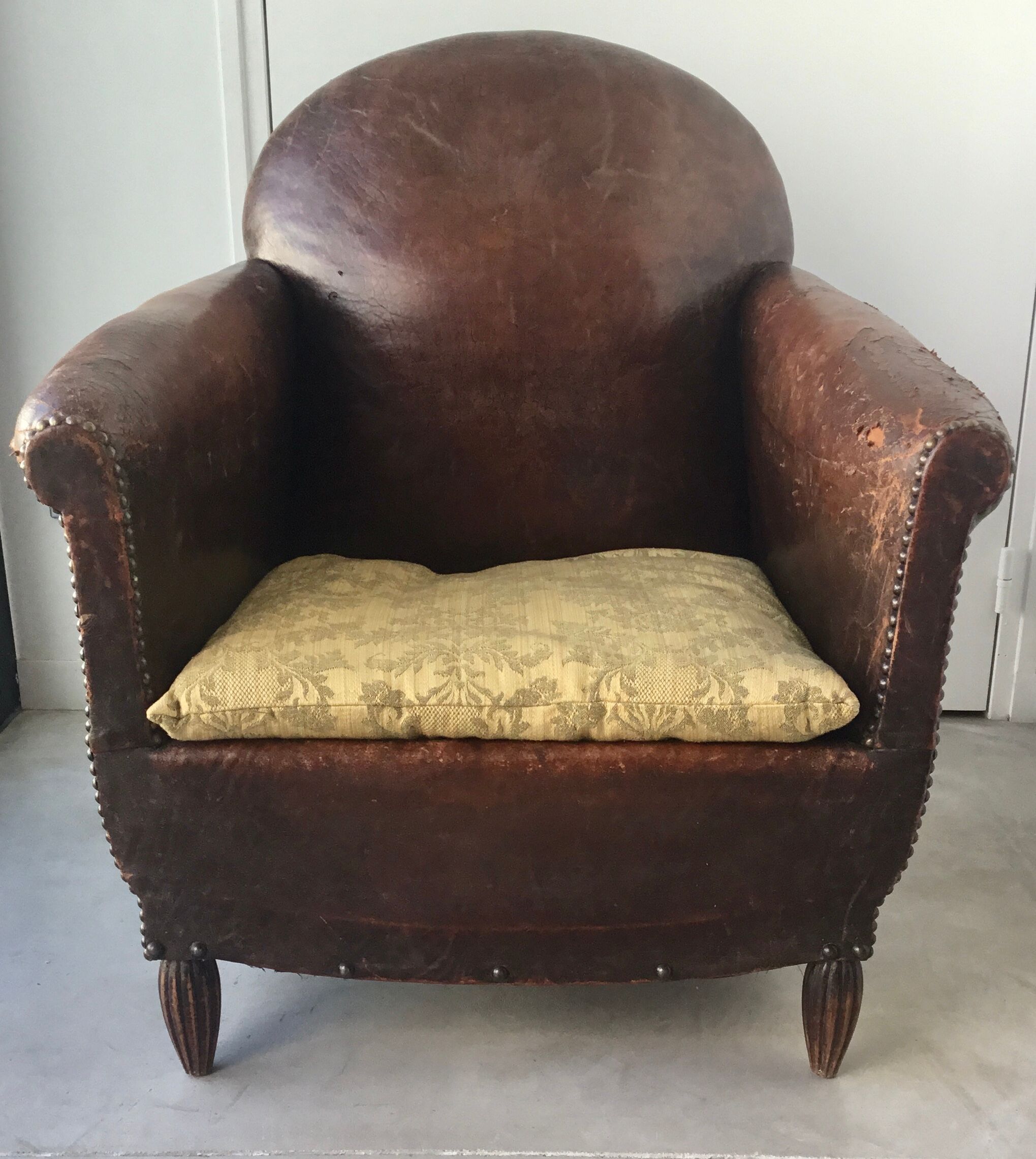Club armchair in studded leather - early twentieth century
