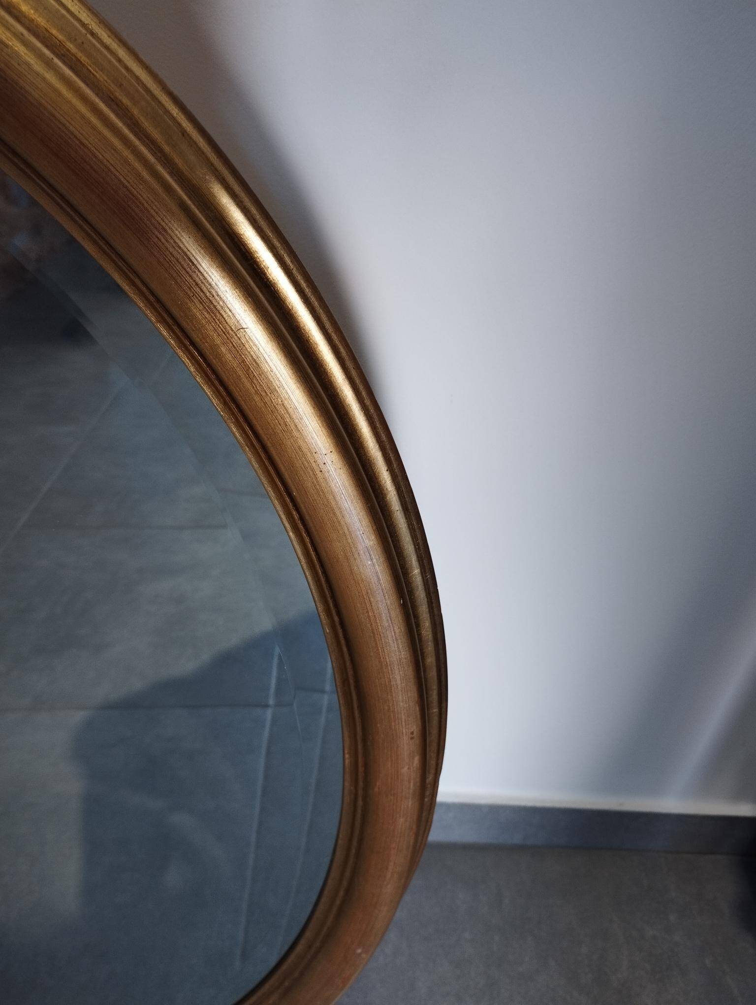 Grand et élégant miroir doré ovale avec sa glace biseauté
