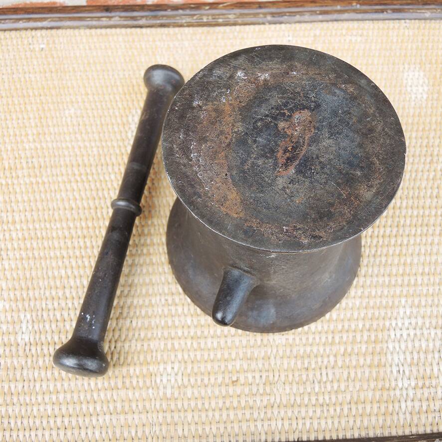Ancient large mortar and pestle of a black cast iron apothecary.